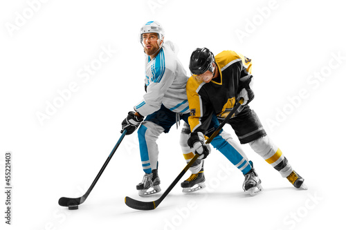 Two professional hockey players on ice. Fight for the puck. Concept of sport, healthy lifestyle, action. Isolated on a white background