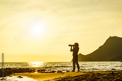 Woman with camera on Monsul beach, Spain
