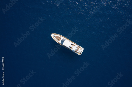 Super yacht on blue water top view. Huge white super Mega yacht on blue water in Italy. White sport yacht open sea aerial view.