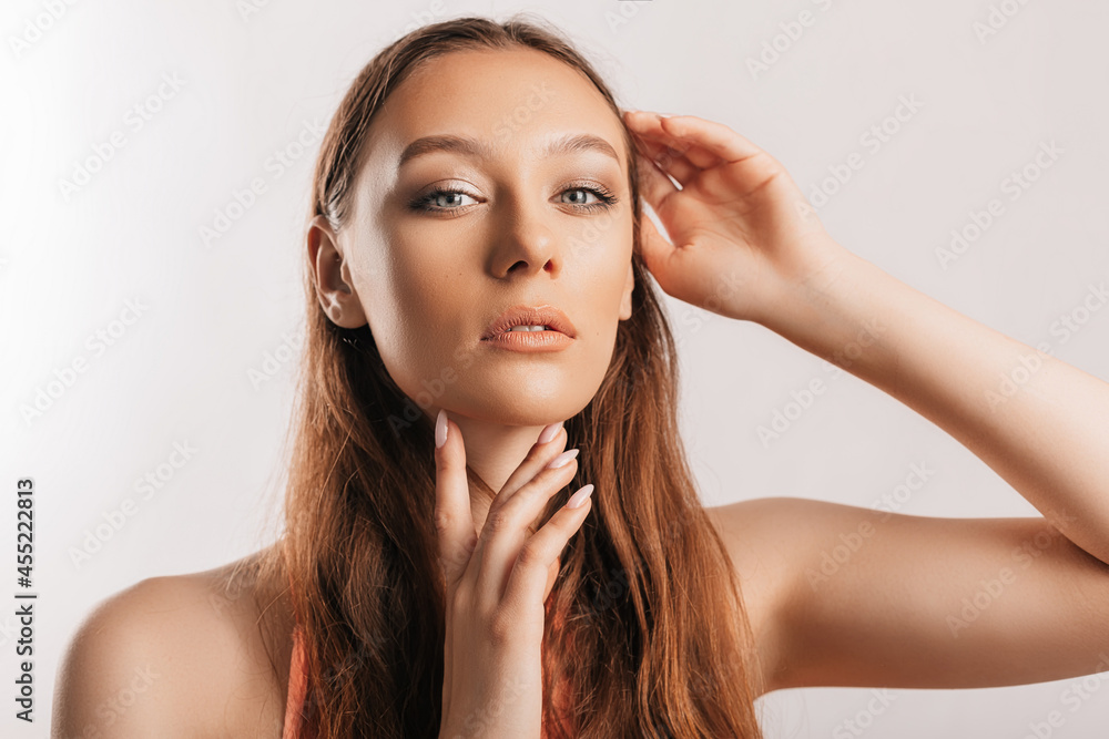 Beautiful young girl smiling and posing looking at the camera on a white isolated background with mockup. Positive brunette woman. Kind look. Beauty face Beautiful young girl smiling and posing looking at the camera on a white isolated background with mockup. Positive brunette woman. Kind look. Beauty face