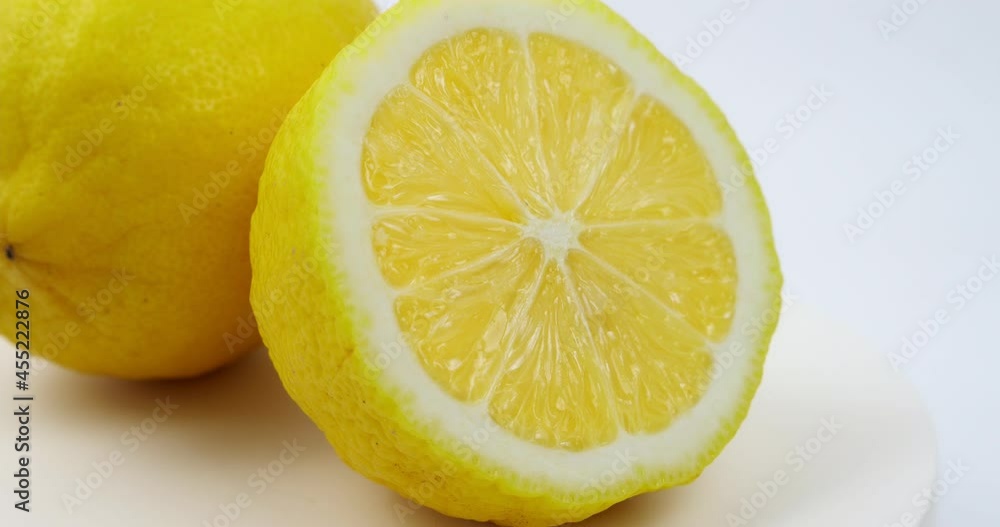 Group of ripe whole yellow lemon citrus fruit with lemon fruit half rotated on white background Group of ripe whole yellow lemon citrus fruit with lemon fruit half rotated on white background