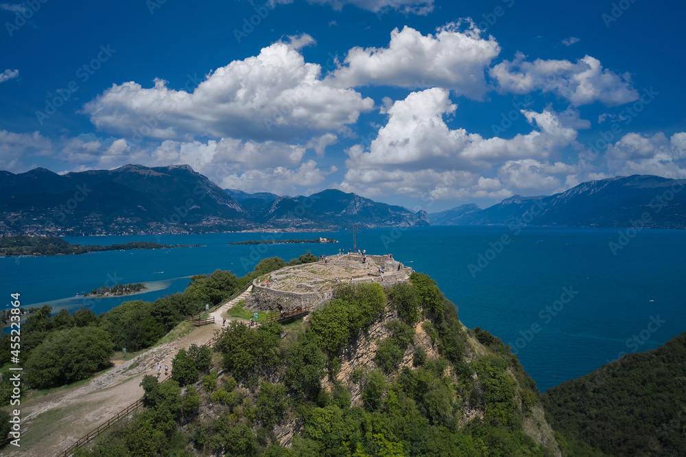 Fortress Rocca di Manerba aerial view. Panorama on the rocca di manerba top view. Fortress with a cross on a hill in the background Lake Garda. Lake Garda, Italy aerial view.