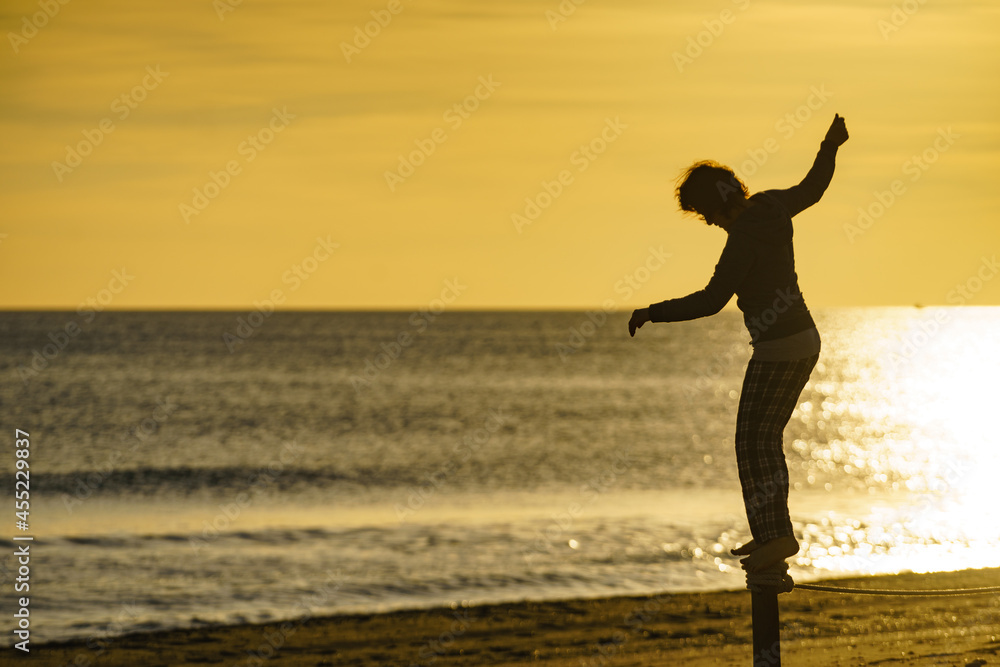 Woman having fun on beach at sunrise