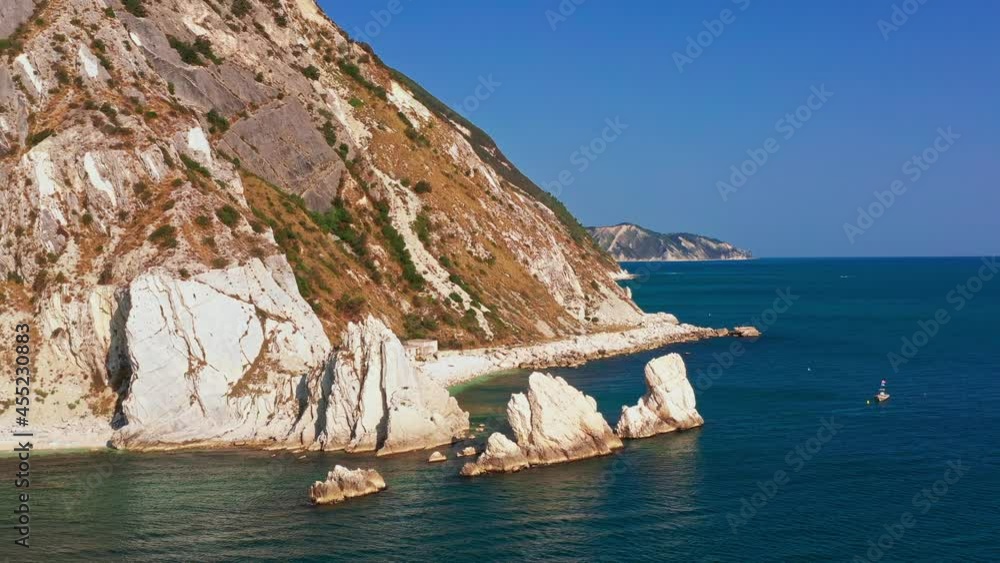 Aerial view of white rocky cliffs, down blue sea, deep white cliffs. White rocks, trees. Sea waves in blue seaside, white rocky bay, in a pristine ecosystem blue sky in a summer day in Conero, Italy Aerial view of white rocky cliffs, down blue sea, deep white cliffs. White rocks, trees. Sea waves in blue seaside, white rocky bay, in a pristine ecosystem blue sky in a summer day in Conero, Italy
