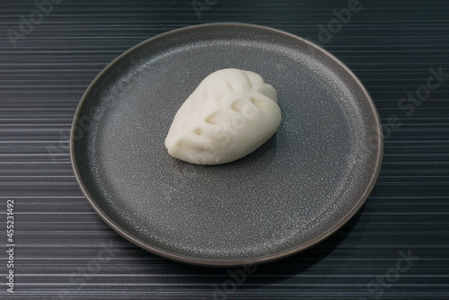 steamed fresh vegetables bun white baozi in leaf shape on dark grey wood background dim sum halal menu