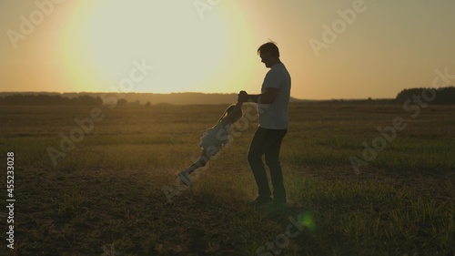 dad is circling little daughter at sunset, silhouette of father and child against sky, happy family, childhood dream, to love and play with kid, girl with parent is playing cheerfully, trip to nature