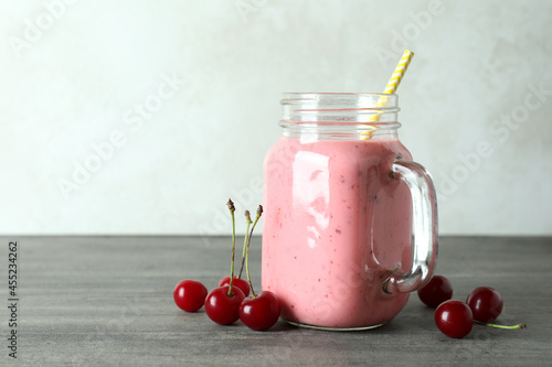 Wallpaper Mural Glass jar of cherry smoothie and ingredients on gray textured table Torontodigital.ca