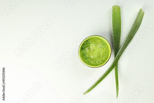 Aloe leaves and bowl with gel on white background
