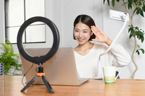 笑顔でライブ配信する若い女性（配信者）