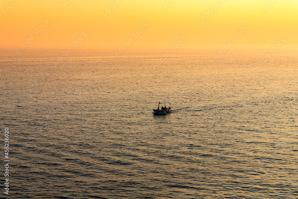 Boat sailing at sea at beautiful golden Sunset