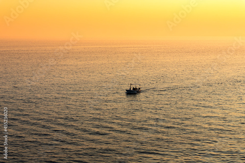 Boat sailing at sea at beautiful golden Sunset © ArtmediaworX