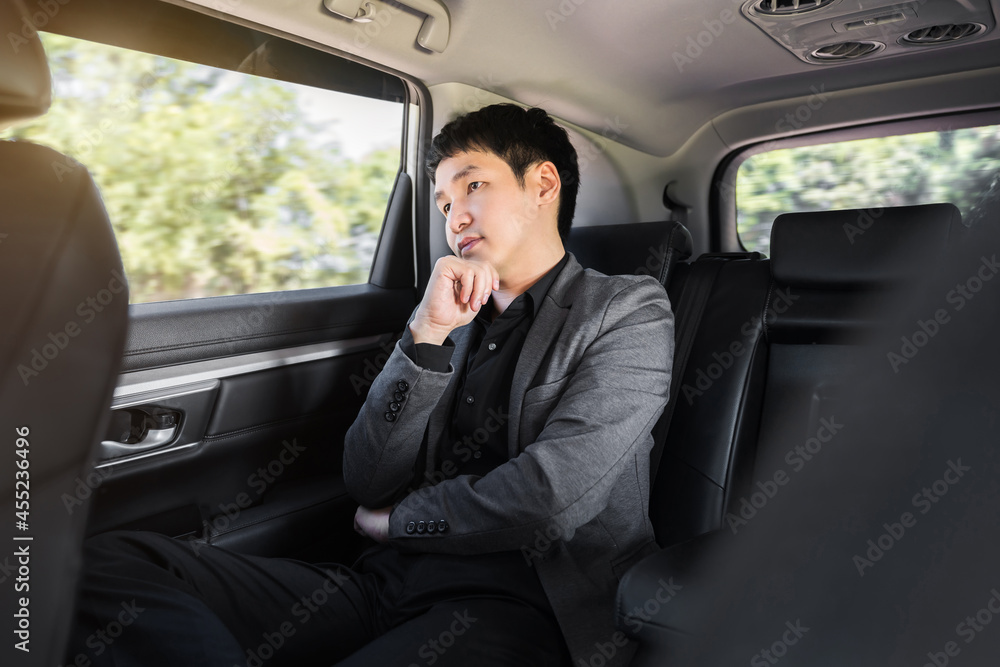 business man thinking while sitting in the back seat of car business man thinking while sitting in the back seat of car