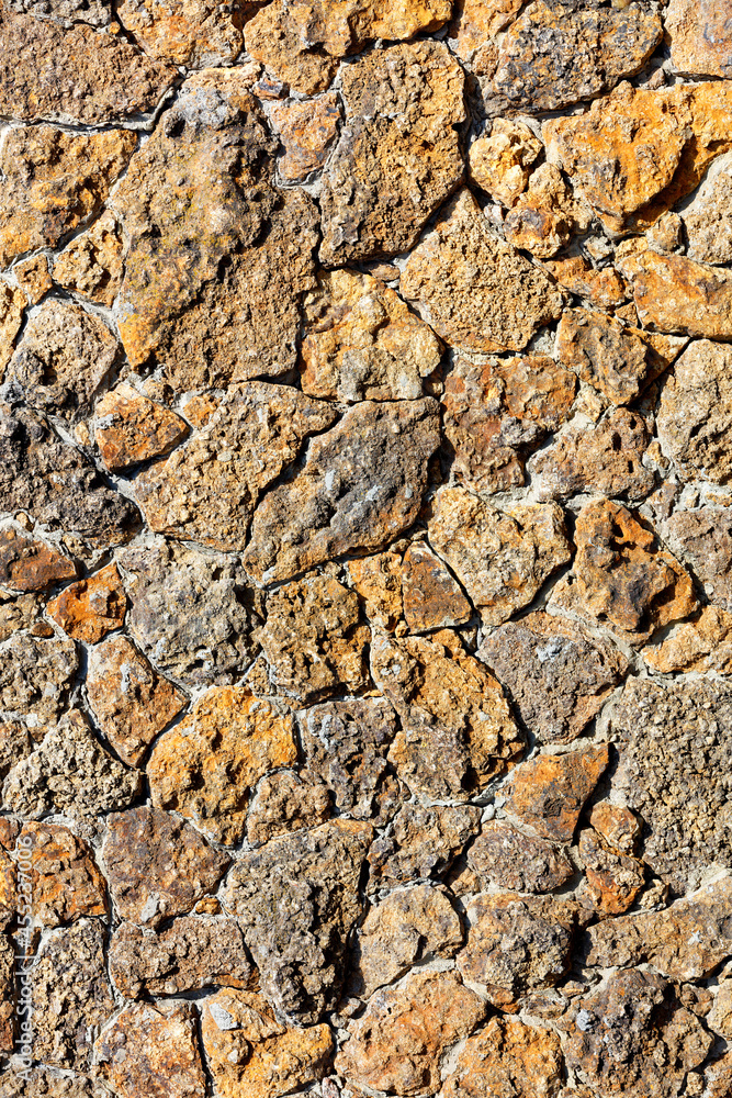 The rough masonry of the wall is lined with old orange shell rock. Vertical image. The rough masonry of the wall is lined with old orange shell rock. Vertical image.