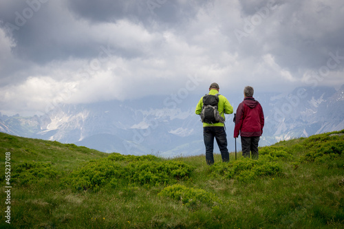 two active old people in modern hiking cloth looking to a mountain © Sebastian