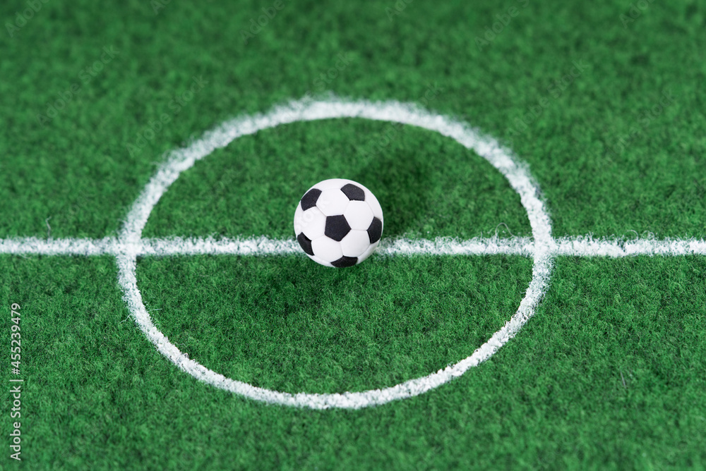 Black and white soccer ball in the center of the soccer field, decoration mini football. Black and white soccer ball in the center of the soccer field, decoration mini football.