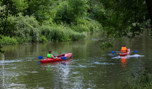 Traveler with paddle and kayak on a small river