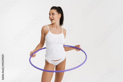 European woman wearing underwear smiling while posing with hula-hoop