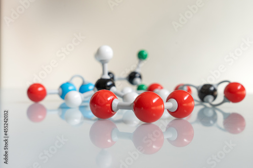 Close-up ozone molecule with differents greenhouse gases at the bottom. Chemical formula of O3 made by molecular model with nitrogen monoxide, carbon dioxide, methane, water and HFC - 125. photo
