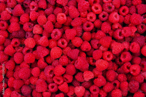 many berries of juicy bright tasty red and pink raspberries, top view. Berry texture for design and print. close-up, background image of food on a flat surface. vegetarian healthy food, dessert
