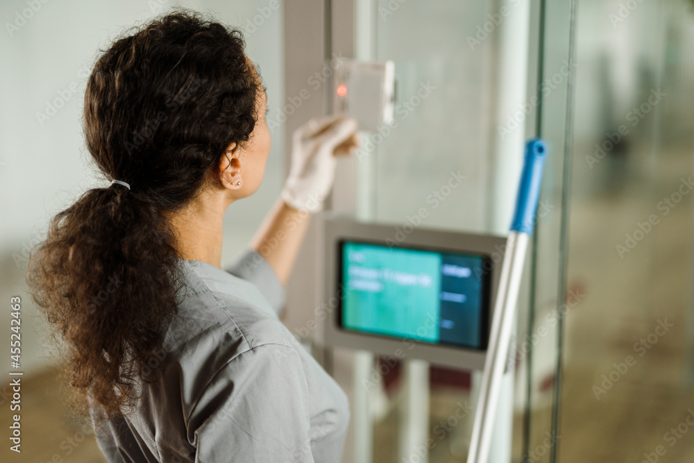 Middle eastern cleaning woman using pass while working indoors Middle eastern cleaning woman using pass while working indoors