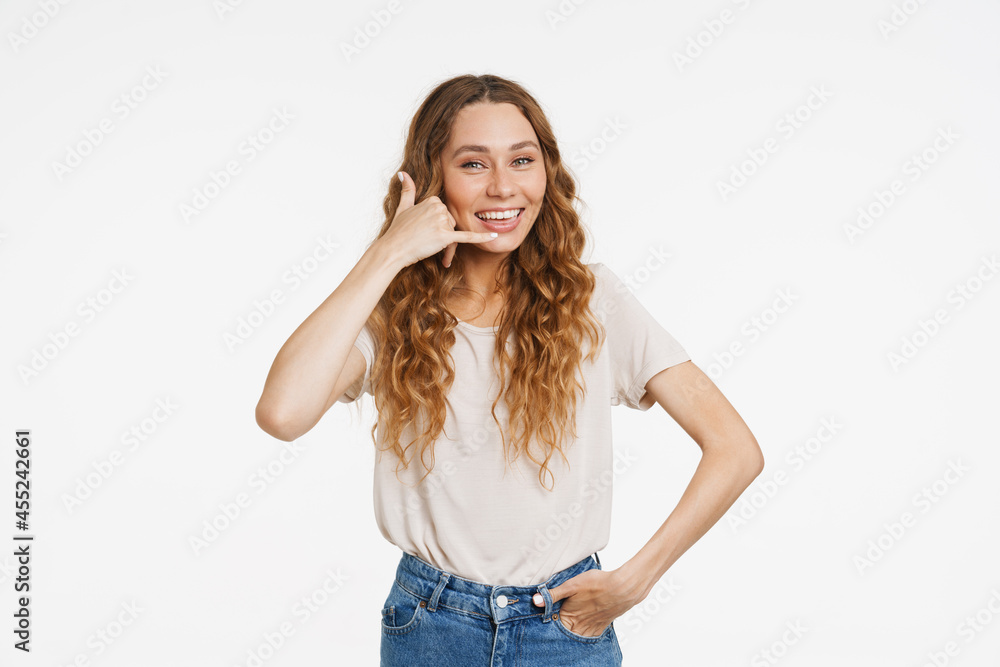 Fototapeta premium Young ginger woman in t-shirt smiling and making handset gesture