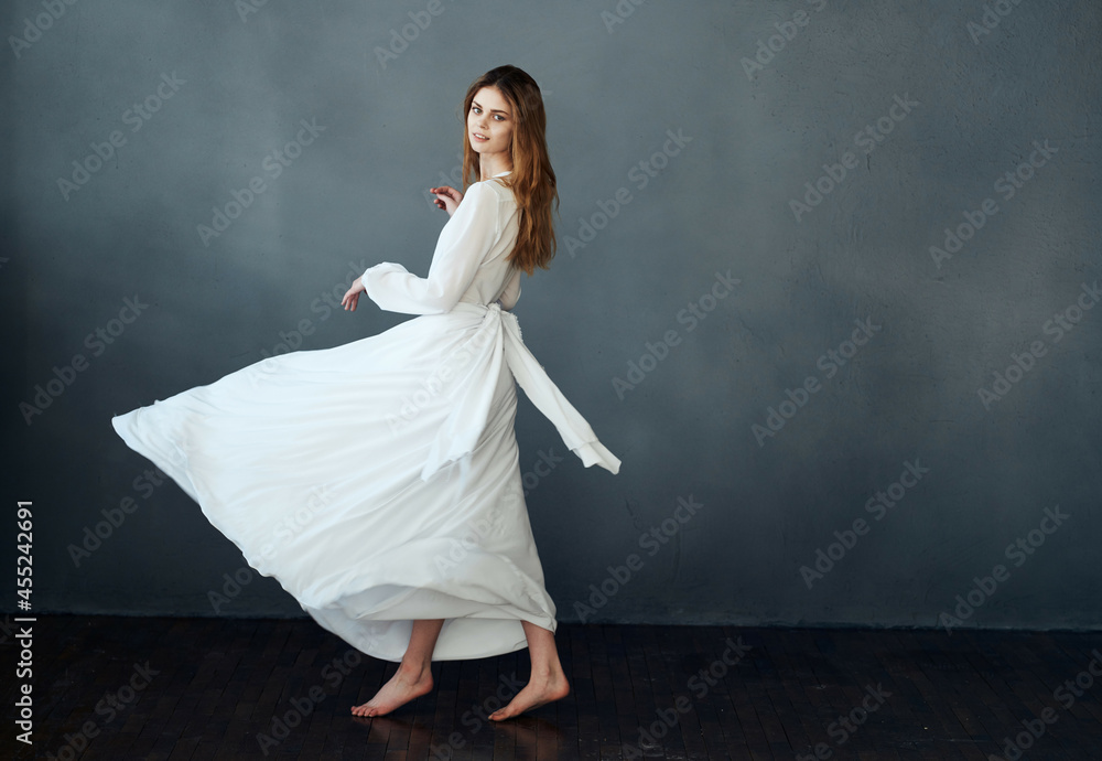 Woman in white dress dance movement performing dark background Woman in white dress dance movement performing dark background