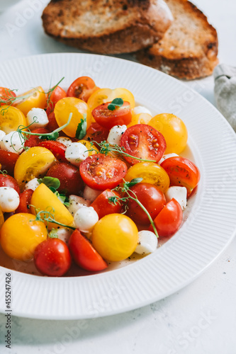 Fresh healthy salad with cherry tomatoes, mozzarella and olive oil
