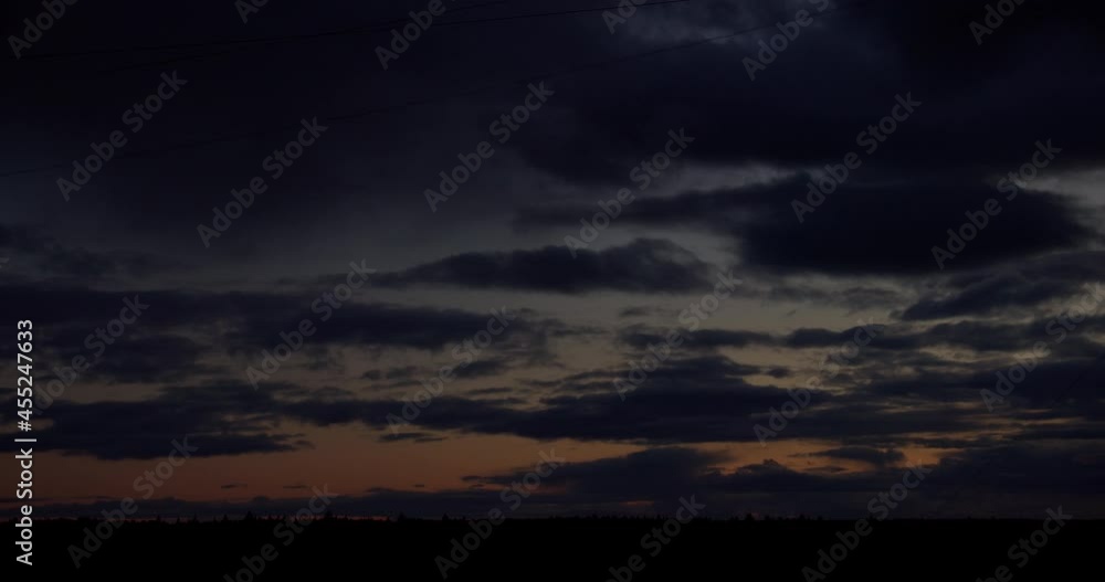 Time-lapse of fast moving dramatic clouds on sky at sunset over forest horizon. From dusk to darkness Time-lapse of fast moving dramatic clouds on sky at sunset over forest horizon. From dusk to darkness