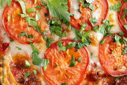 Pizza with tomatoes and parsley, top view. Macro