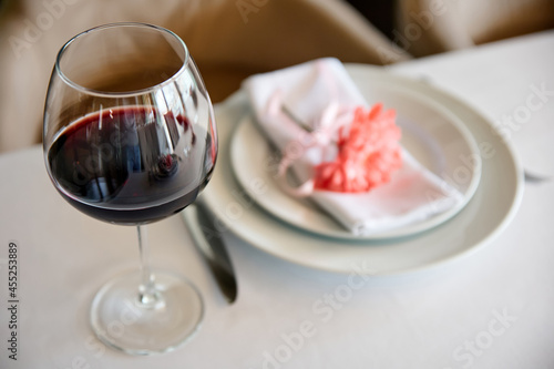 Glass of red wine on background of served table in a restaurant. Close-up  selective focus