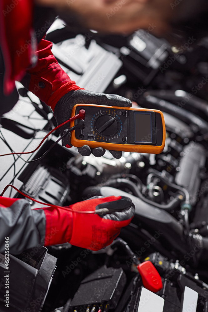 Mechanic checking battery of car in workshop Mechanic checking battery of car in workshop