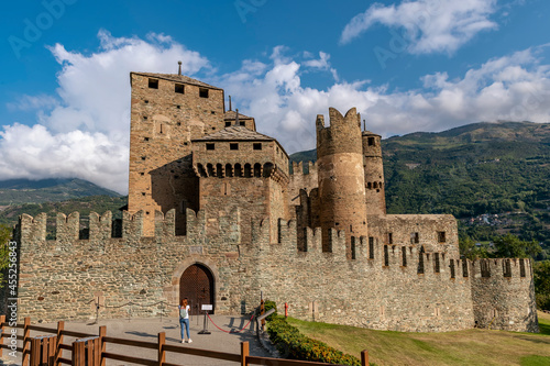 A lonely girl with red hair photographs the castle of Fénis, Valle d'Aosta, Italy photo
