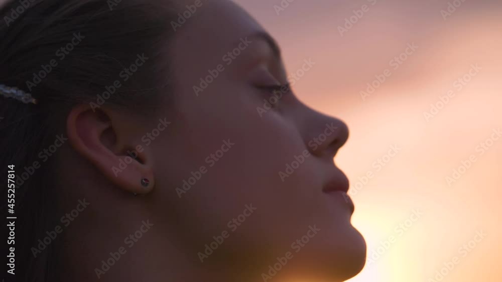Portrait of a happy young teenager girl on the street. The girl dreams with pleasure with her eyes closed. The lady feels free, successful, ready to start the day, move forward. Portrait of a happy young teenager girl on the street. The girl dreams with pleasure with her eyes closed. The lady feels free, successful, ready to start the day, move forward.