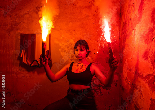 Galatasaray soccer fan woman holding a yellow, red torch in an old interior. Dark Scene, Copy Space. photo