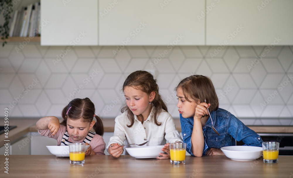Portrait of three girls sisters indoors at home, eating breakfast. Portrait of three girls sisters indoors at home, eating breakfast.