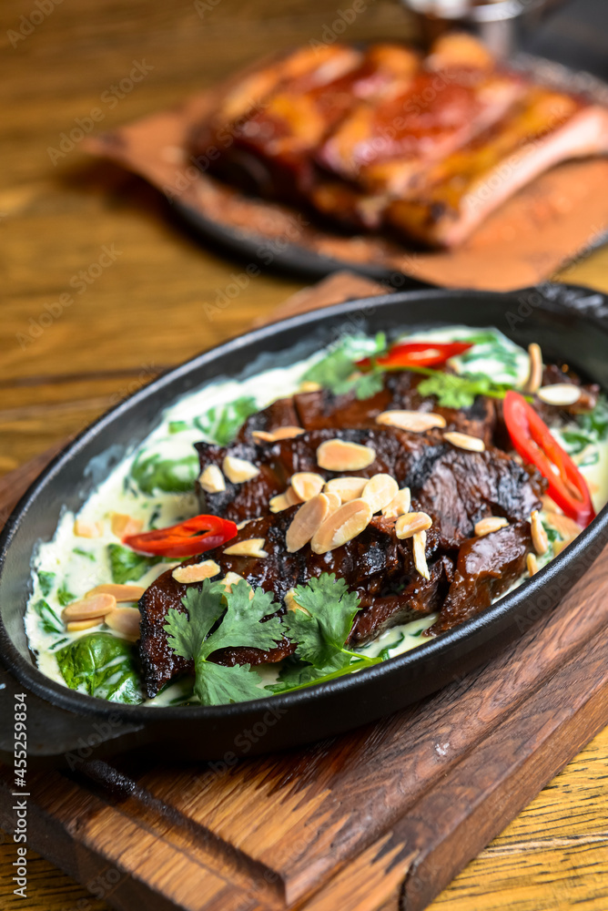 Meat with vegetables served with sauce in a pot over rustic wooden background. Rustic style dinner Meat with vegetables served with sauce in a pot over rustic wooden background. Rustic style dinner