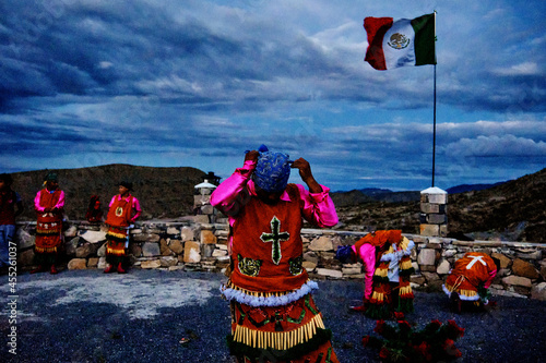 Traditional Mexican dancers getting ready for a performance with Mexican flag behind
