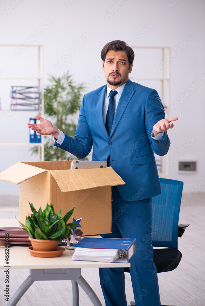 Young male employee in business relocation concept Young male employee in business relocation concept