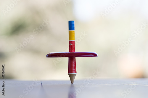 Colorful wooden peg-top or a teetotum on a blurred background photo