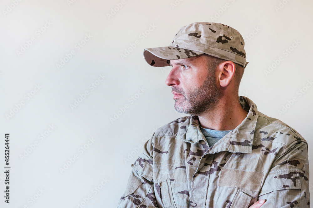 Fototapeta premium Caucasian man in camouflaged army uniform crossing arms