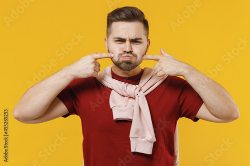 Vászonkép Young fun man 20s in red t-shirt point index fingers on blowing puffing cheeks w