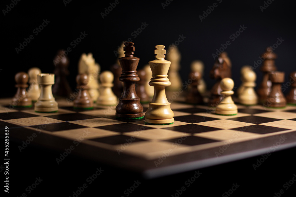 Chess board with spaced figures on a dark background, concept of an intelligent task or business strategy