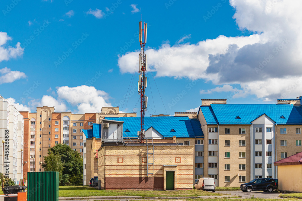 Cellular antenna against a blue cloudy sky in a residential residential area. Modern communication technologies. Cellular antenna against a blue cloudy sky in a residential residential area. Modern communication technologies.