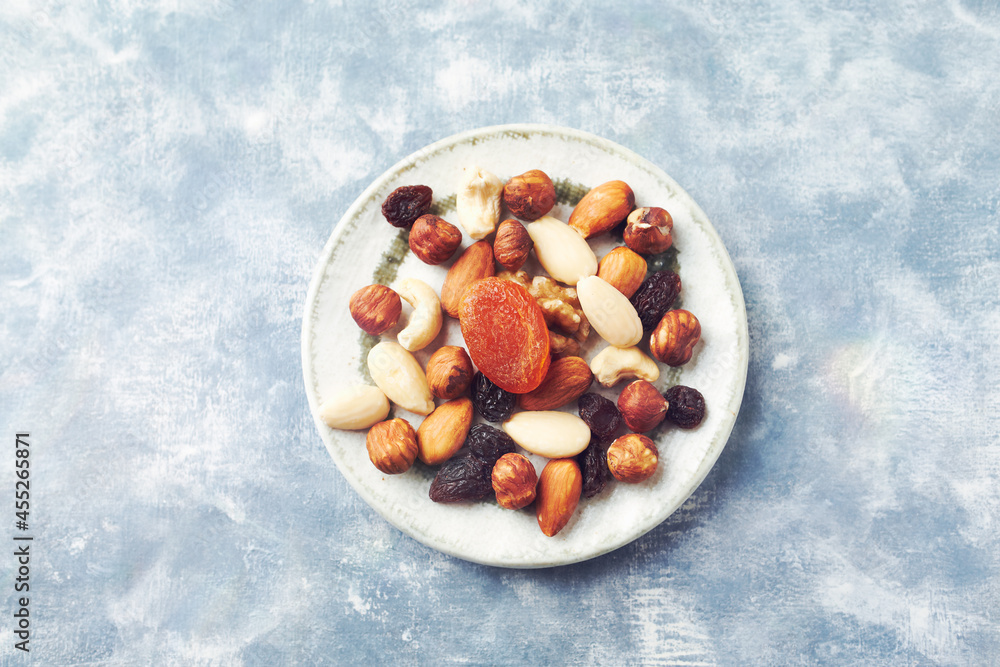 Nuts, raisins and apricots on rustic wooden background. Concept for healthy snack. Top view. Copy space. Nuts, raisins and apricots on rustic wooden background. Concept for healthy snack. Top view. Copy space.