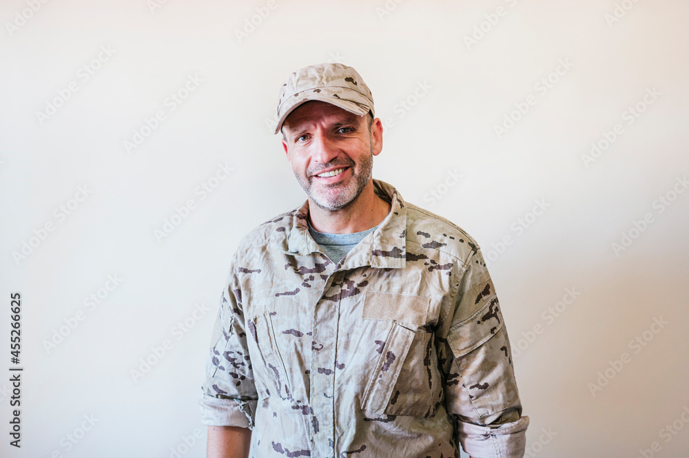 Caucasian man in camouflaged army uniform crossing arms Caucasian man in camouflaged army uniform crossing arms