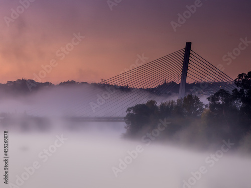 Pont surplombant le fleuve Mondego sous le brouillard au lever du soleil (Coïmbra, Portugal)