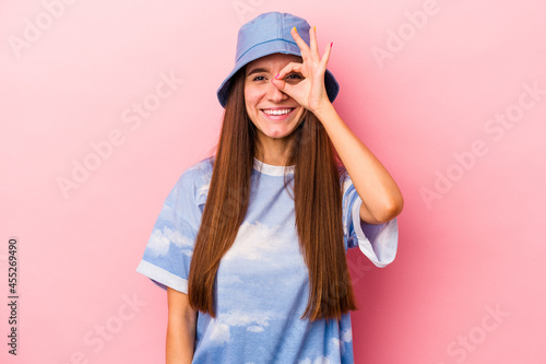 Young caucasian woman isolated on pink background excited keeping ok gesture on eye. © Asier