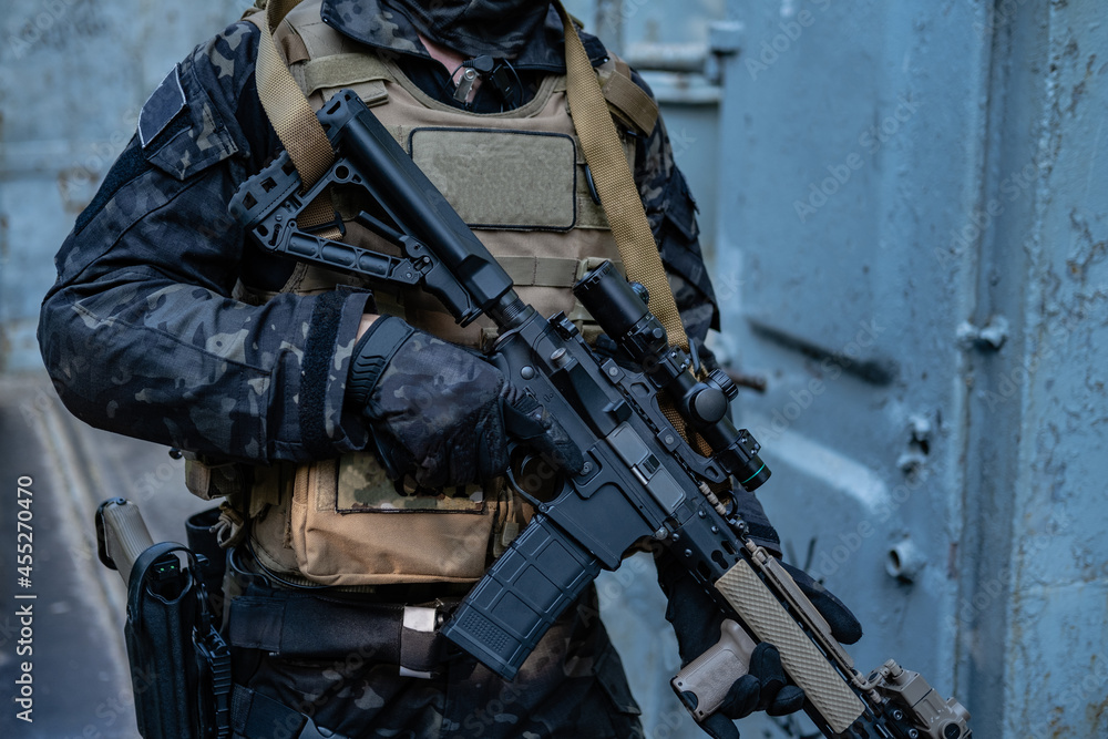 modern soldier in black multicam uniform with rifle, urban background modern soldier in black multicam uniform with rifle, urban background