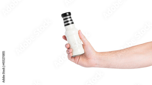 Sauce in a bottle isolated on a white background. Bottle in hand.