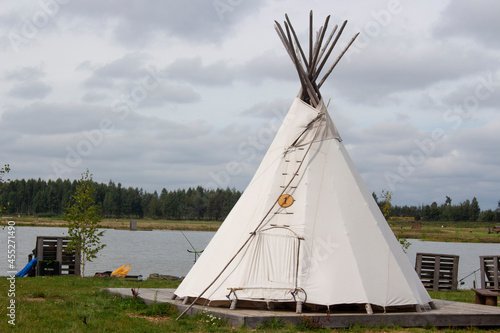 Great view of the tent, wigwam in the field. The wigwam is built on green grass. © Ihar